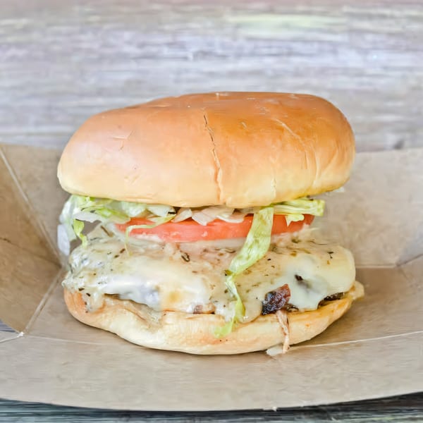 A Brake Burger Garage burger with melted cheese, lettuce, and tomato on a bun, in a paper tray.